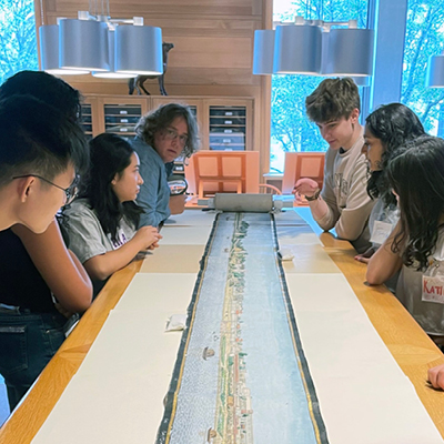 Students gathered around painted scroll